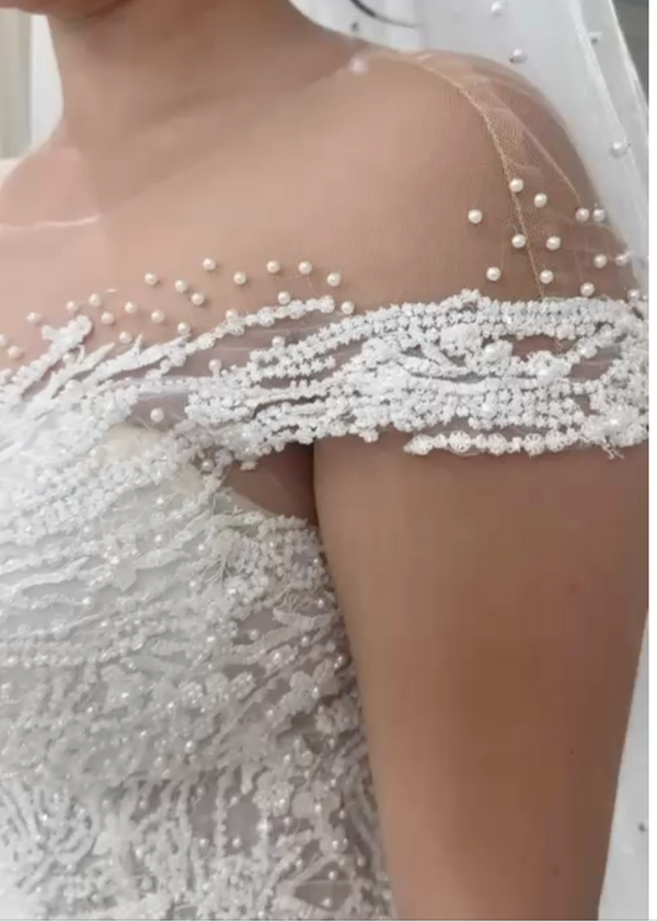 Vestido de novia linea A con cuello transparente y detalles de perlas